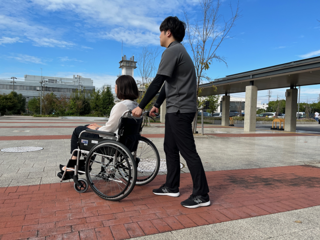 写真：車いすを押す様子